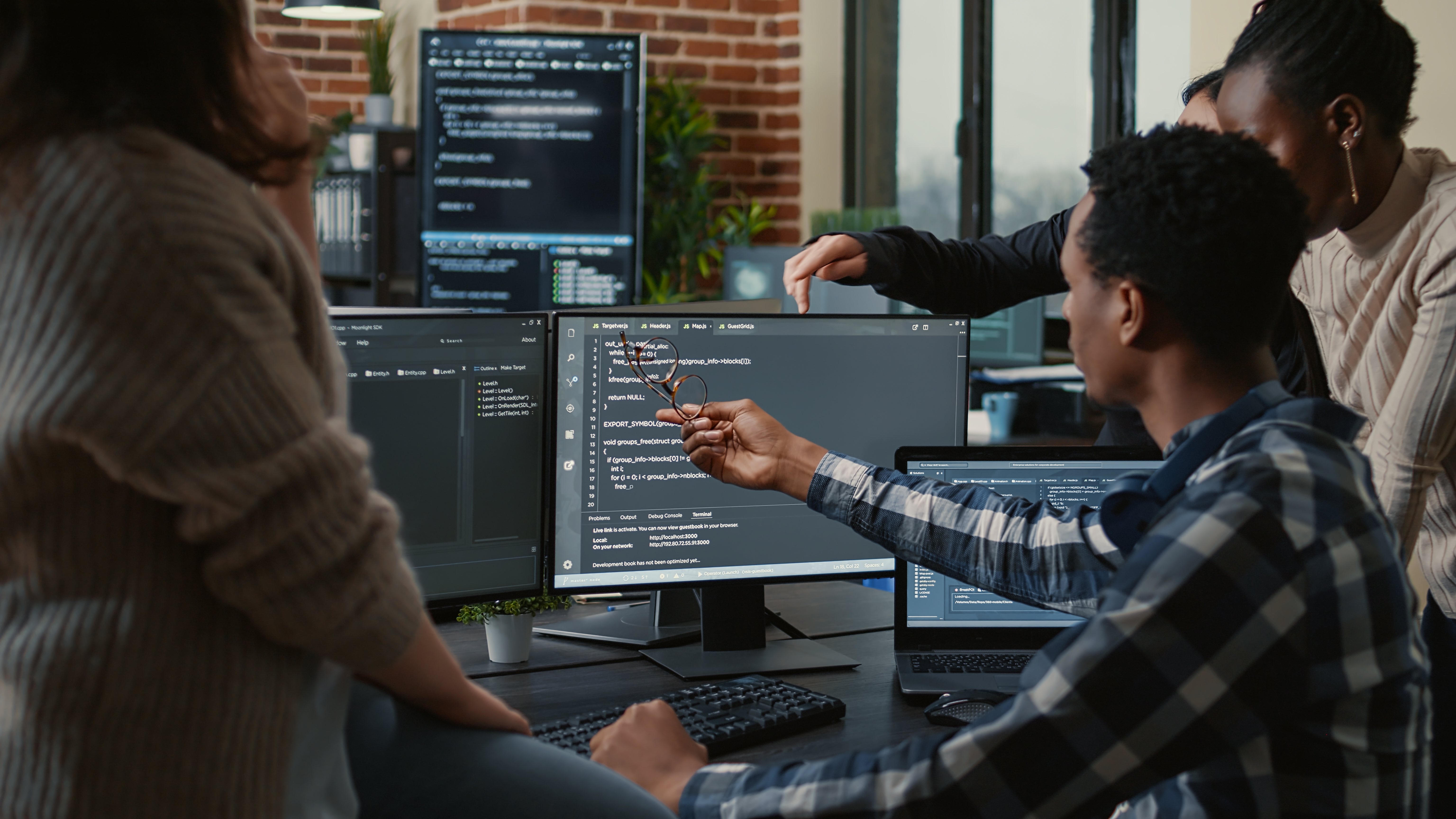 A group of developers around a computer discussing code