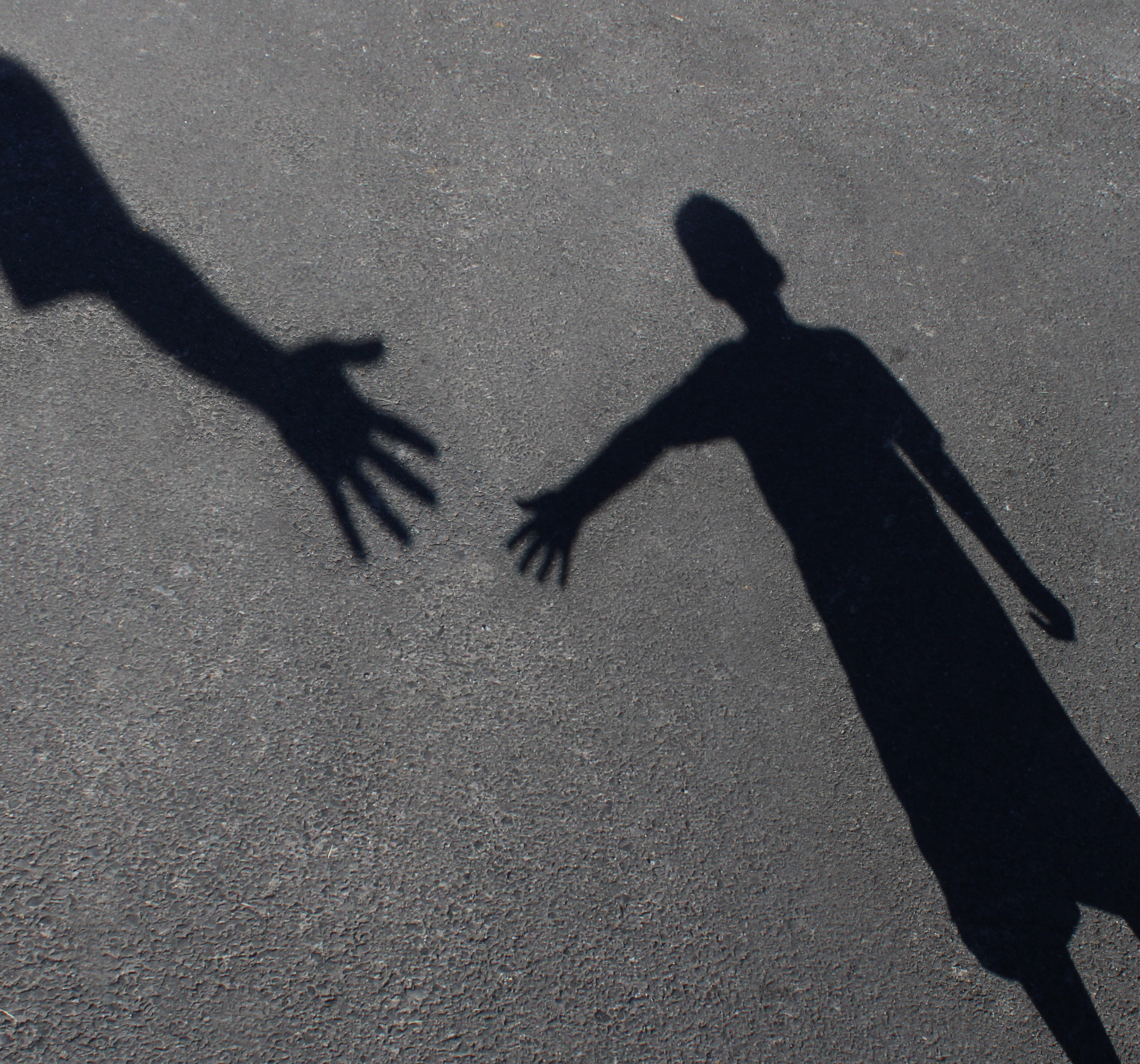 Silhouettes if two people's hands coming together in a hold