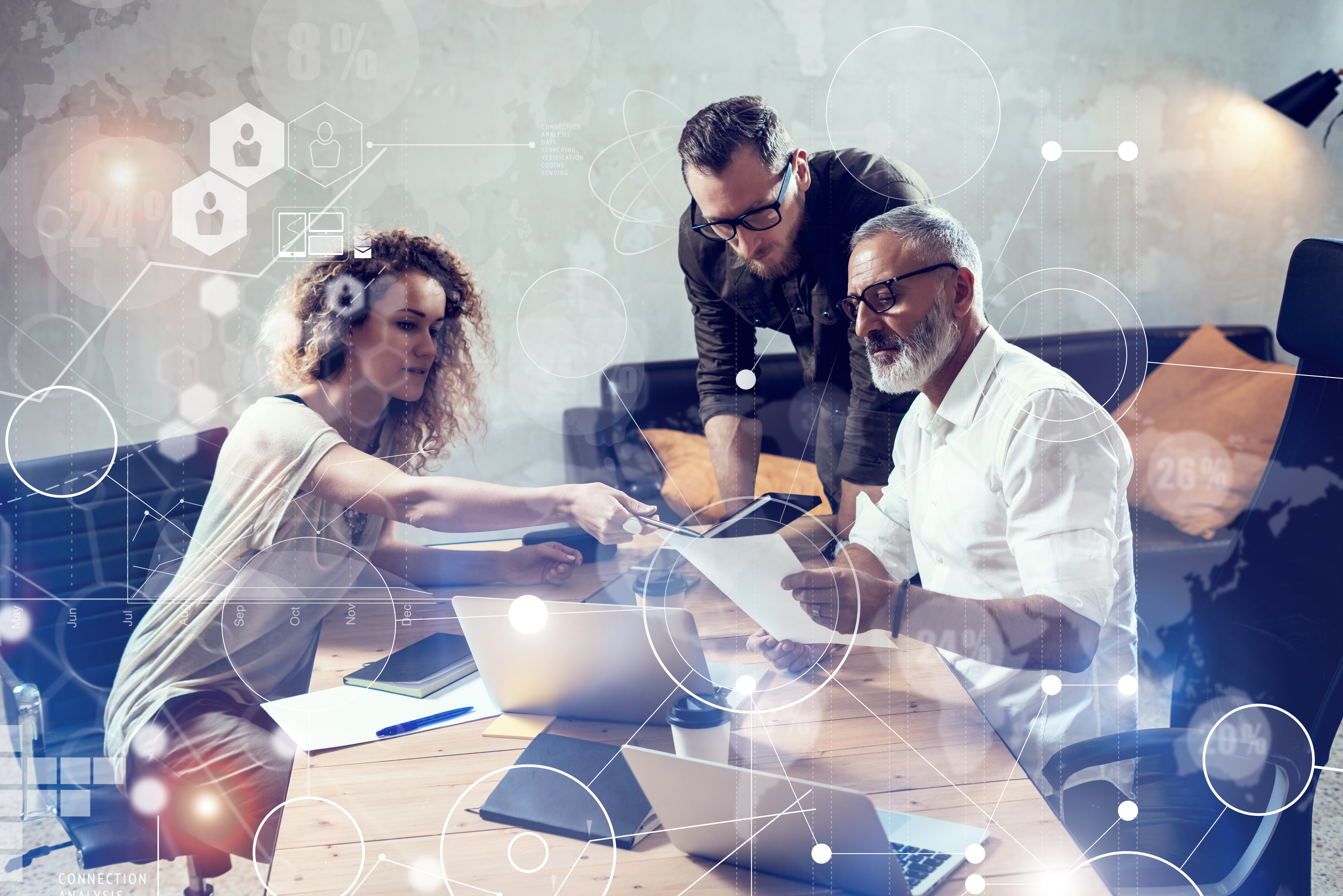 A team of people working together around a laptop